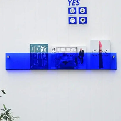 Murale en acrylique transparent avec magazines, livres et journaux, apportant une touche moderne à la décoration intérieure.