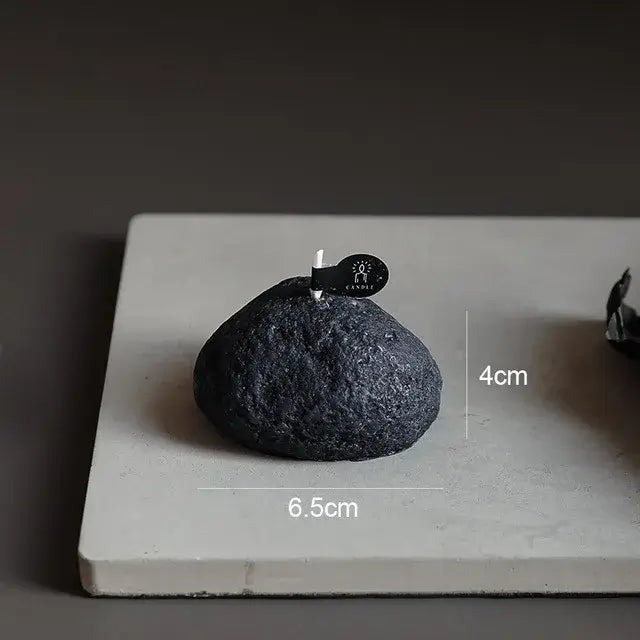 Bougie Parfumée Géométrique Météorite en forme de roche 3D noire sur une tablette grise, dimensions 6,5 cm x 4 cm.
