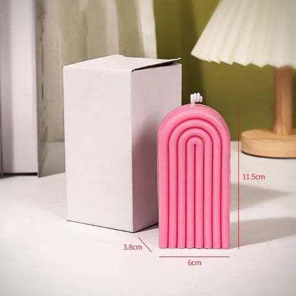 Bougie d'aromathérapie arche en cire de soja rose à côté d'une boîte en carton sur une table