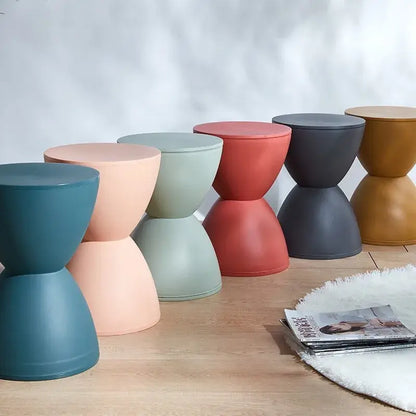 Multicolored minimalist stools lined up on a wooden floor, each featuring a modern and elegant design suitable for contemporary interiors.