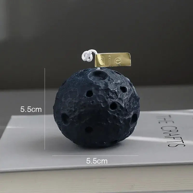 Bougie Parfumée Géométrique Météorite en forme de sphère noire sur une table mesurant 5.5 cm de haut et 5.5 cm de large.