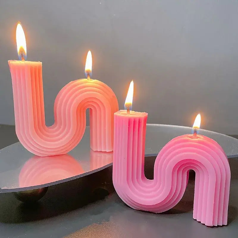Bougie parfumée en forme de S, élégante et minimaliste, allumée pour créer une ambiance apaisante et raffinée dans votre intérieur.
