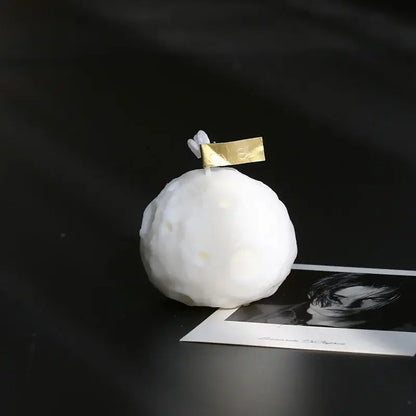 Bougie Parfumée Géométrique Météorite en forme de météorite 3D sur une surface noire, ajoutant une touche moderne et apaisante à la décoration intérieure.